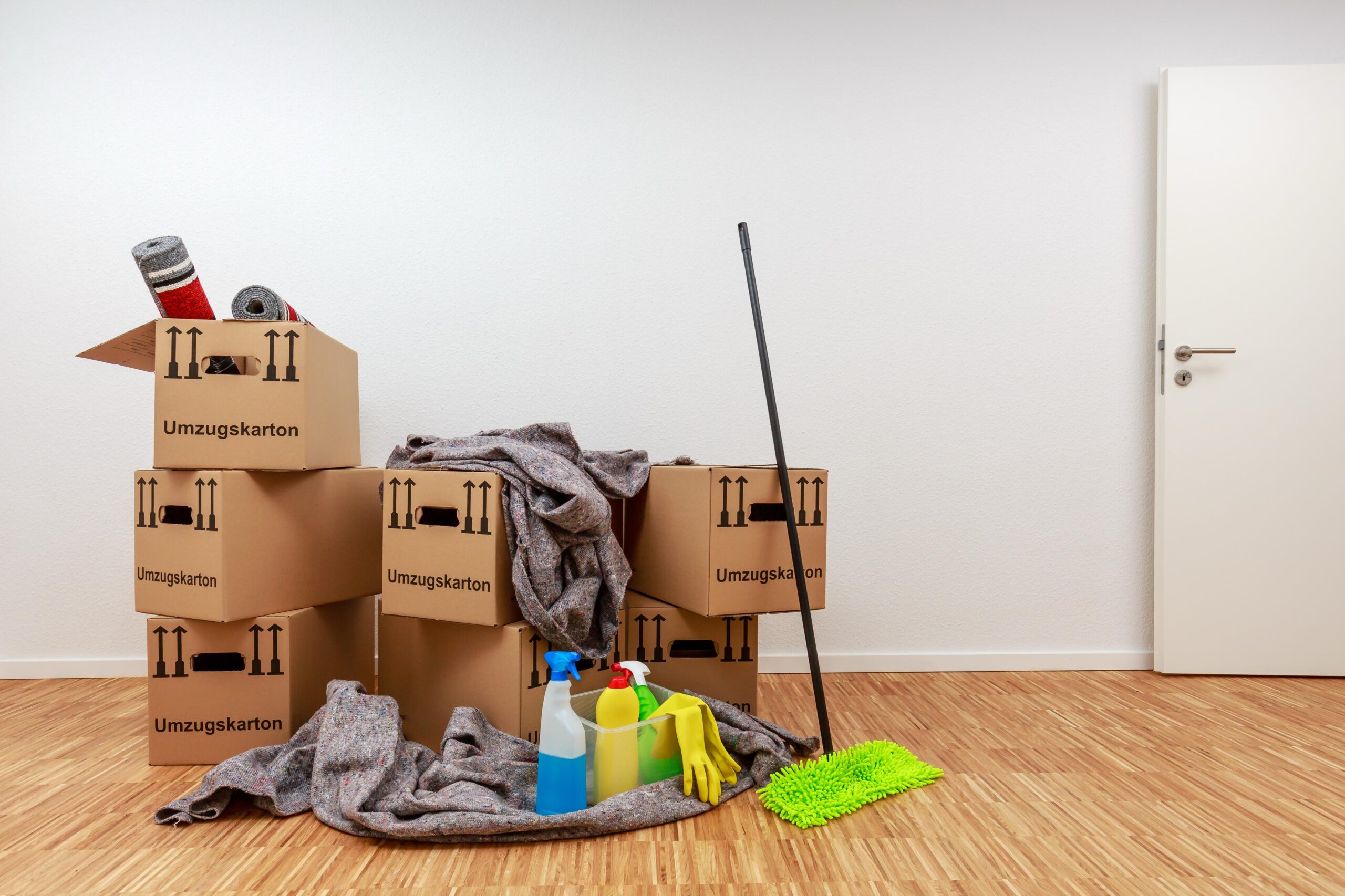 Leere Wohnung in Wattenscheid mit gepackten Umzugskartons und Reinigungsutensilien nach der Entrümpelung.